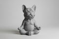 Gray ceramic bulldog figurine sitting in a meditative pose on a light gray background