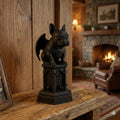 Statue of a dog on a pedestal in a cozy room with a fireplace.